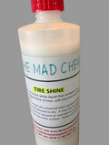Bottle of The Mad Chemist's Tire Shine with a red cap on a gray background
